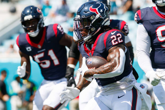 Texans running back Mike Boone runs with the ball with defensive end Will Anderson Jr. behind during the warm-ups against the Jacksonville Jaguars at EverBank Stadium